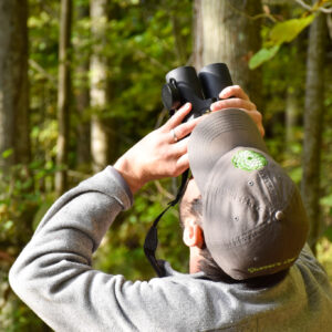 A man with binoculars watches for birds