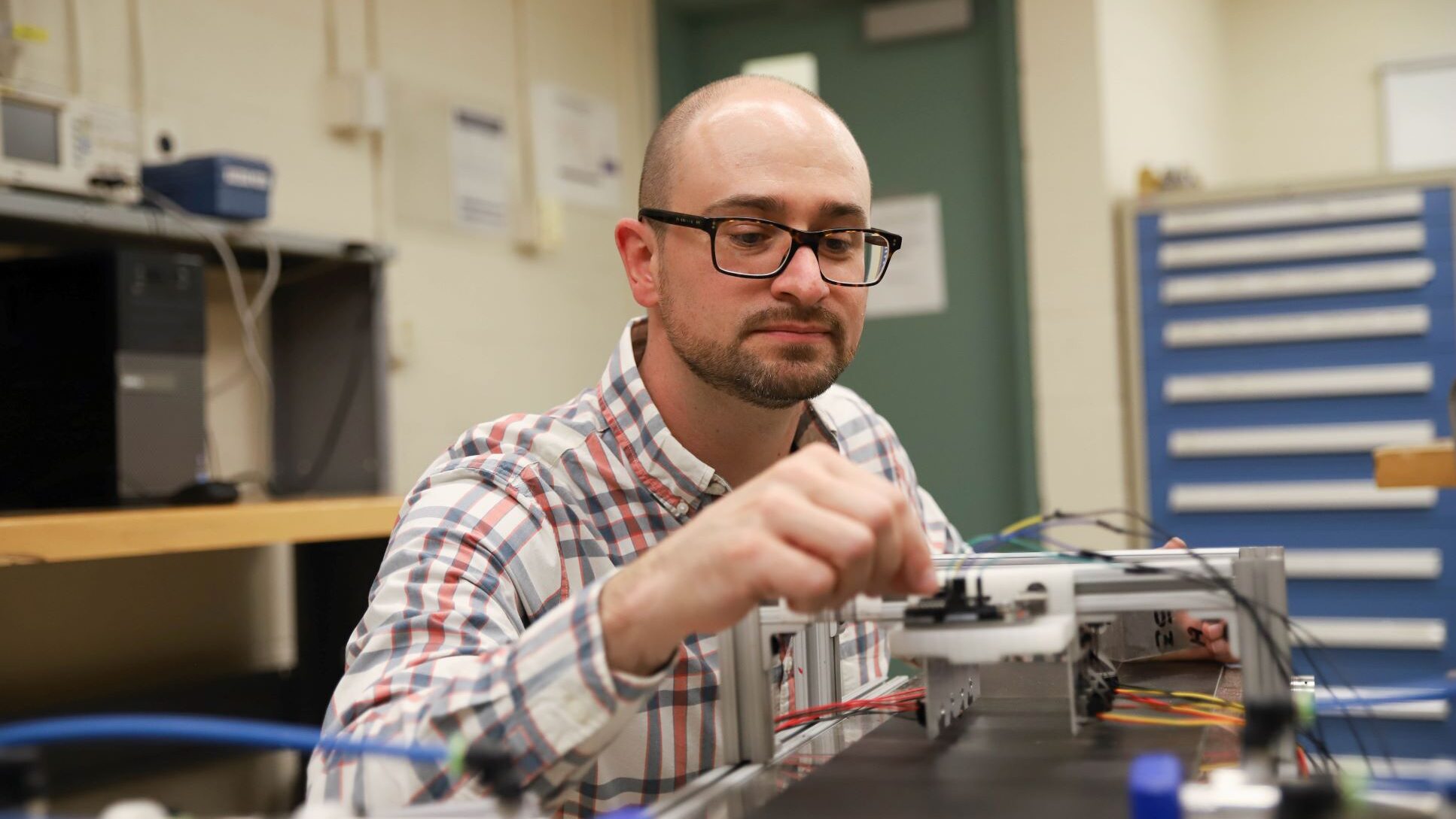 Joseph Cuiffi, Penn State alumnus and current assistant teaching professor and program coordinator of electro-mechanical engineering technology at Penn State New Kensington, works in a campus lab.