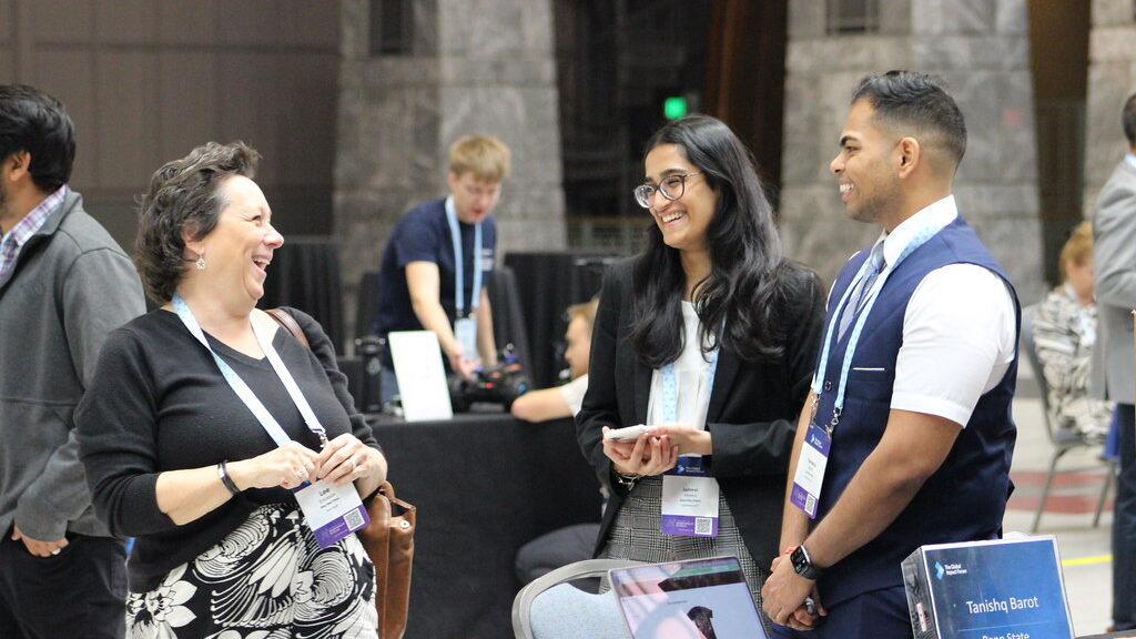 Two students speaking with a Penn State staff member at TGIF 2024.